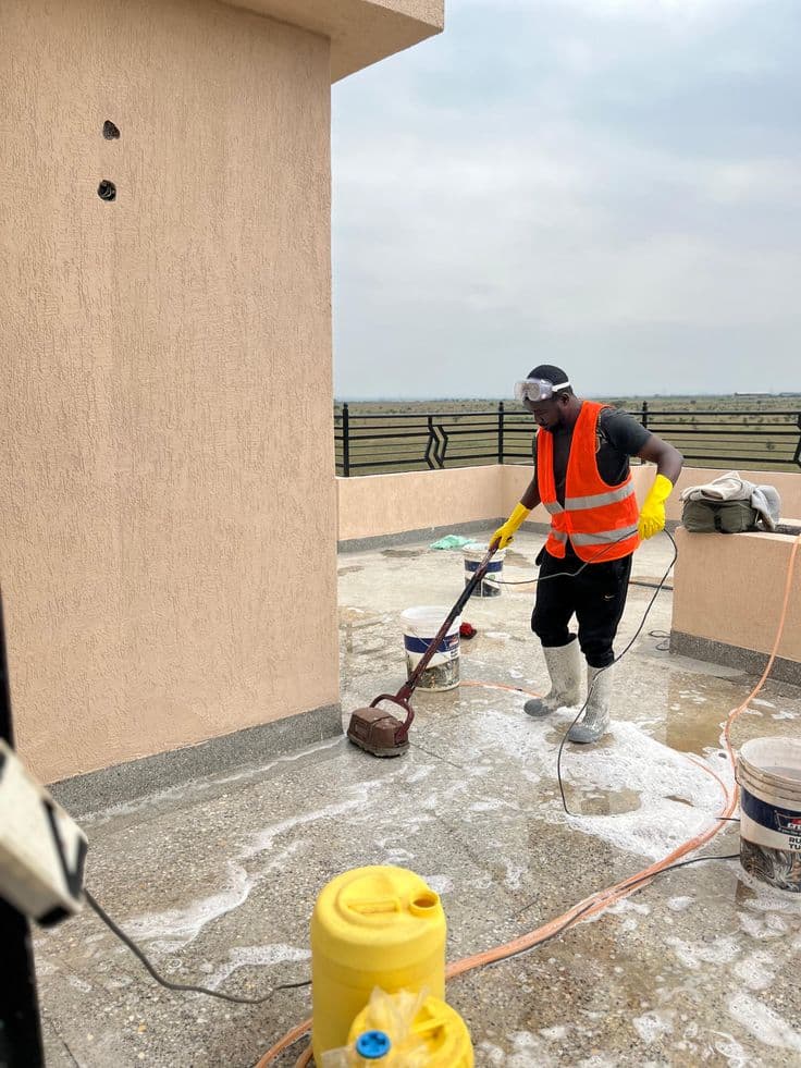 Crew member scrubbing down an outdoor terrace during a handover clean